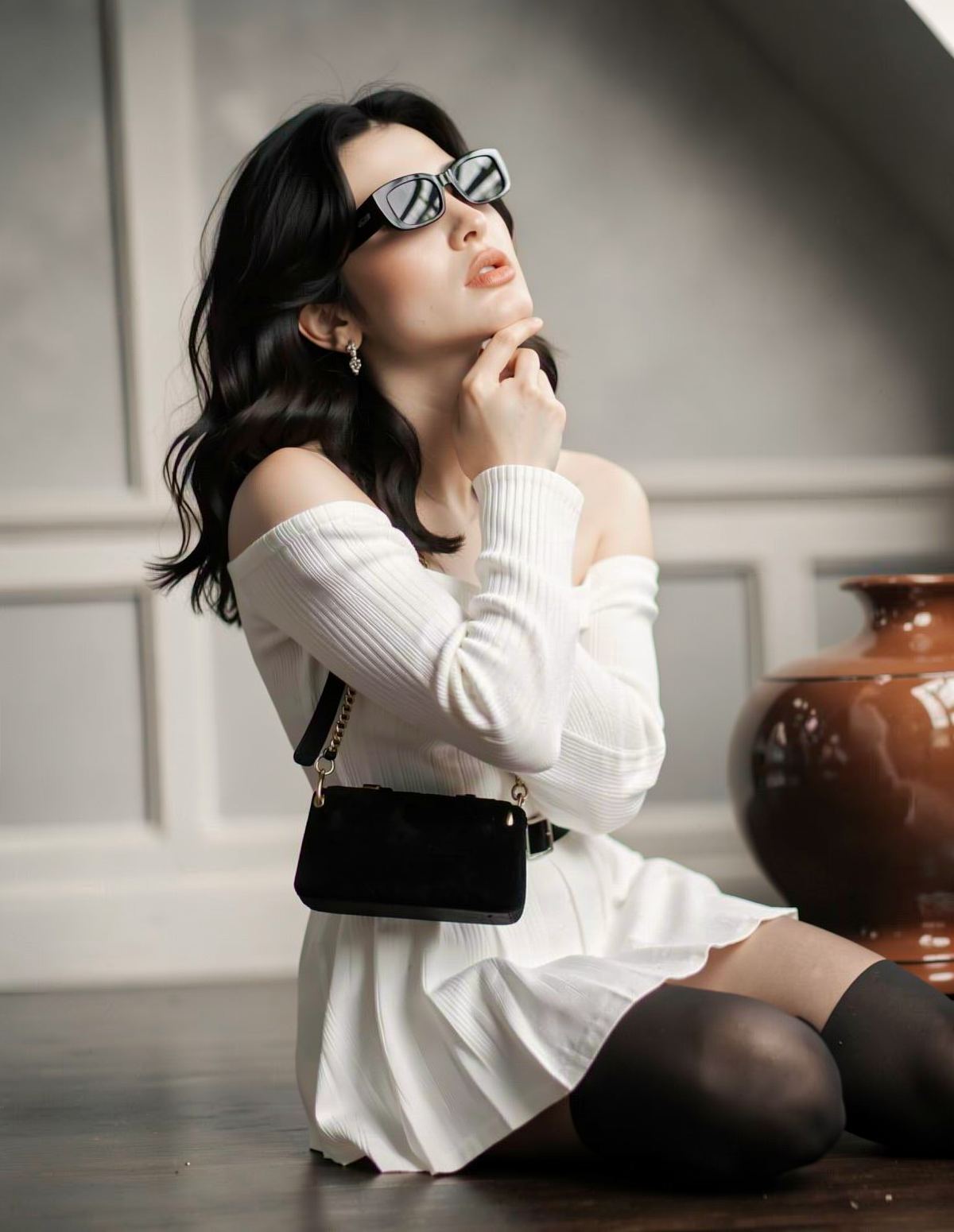 Editorial close-up of the character in a white ribbed dress